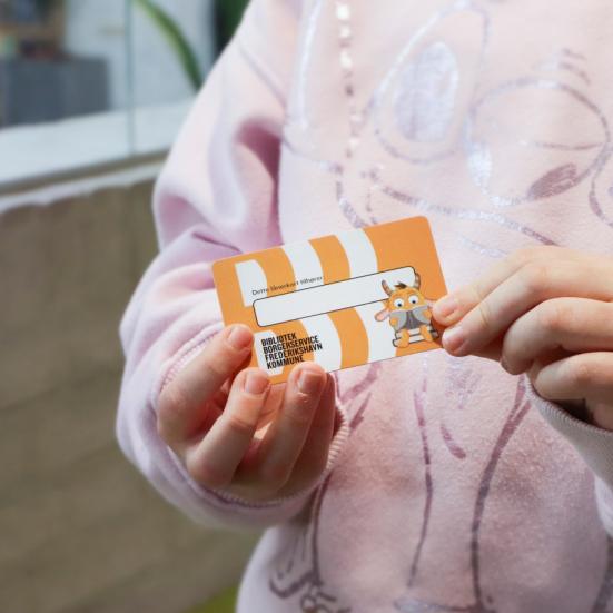 Billede af børnehænder med lånerkort i hånden