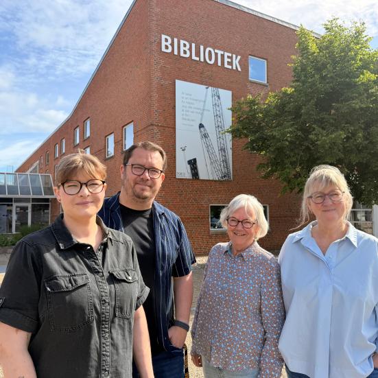 fire bibliotekarer står ude foran biblioteket