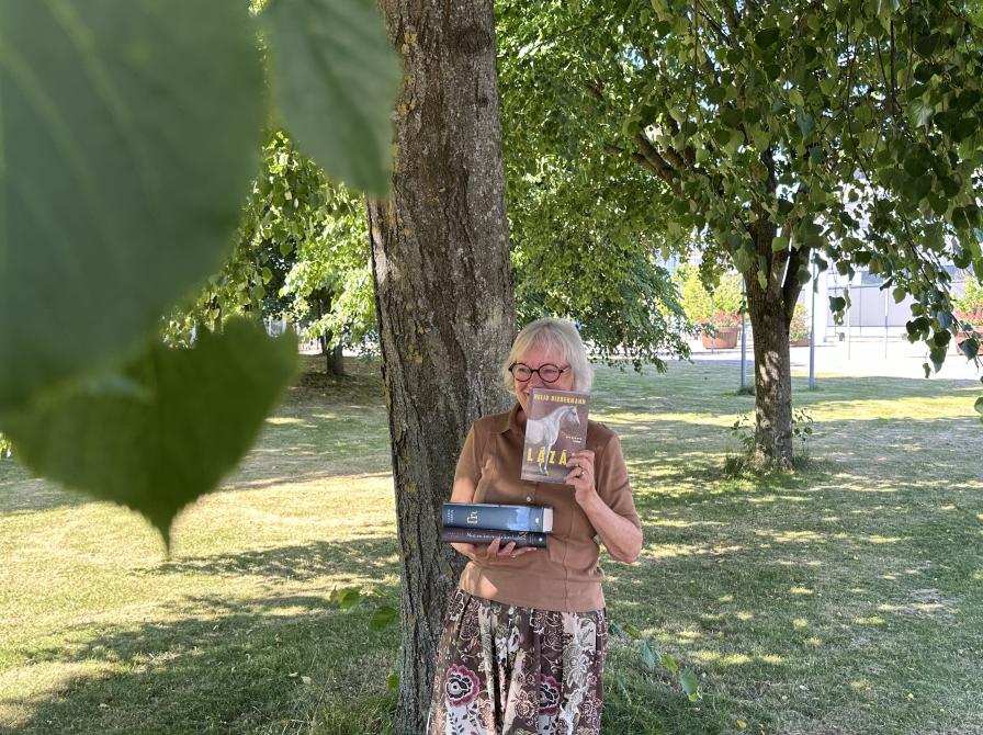 Bibliotekar med bøger ude foran biblioteket